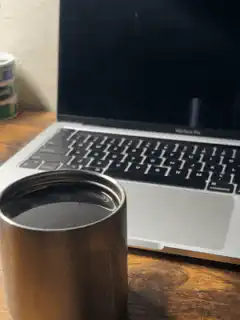 coffee cup in front of laptop
