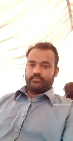 Man in blue shirt under tent