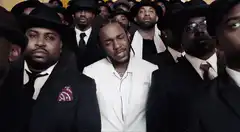 Quavo surrounded by men in suits