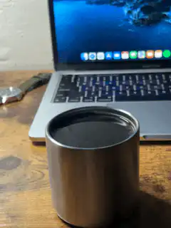 Still shot of a metal cup and laptop