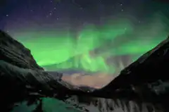 Aurora Borealis over snowy mountains