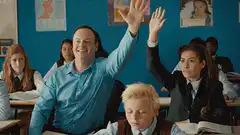 Teacher raises hand in classroom