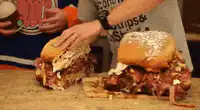 Two giant messy sandwiches on a table