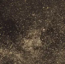 Bitcoin logo emerging from gold dust