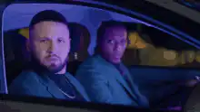 Two men in a car looking at the camera