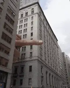 giant hand pointing at building