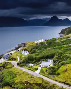 Houses on a green hillside by the sea