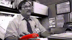 Man in office with red stapler
