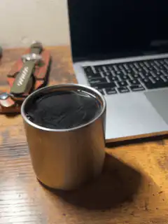 Coffee cup on desk next to laptop