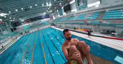 Man in yellow trunks rolls forward off diving board