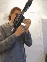 Man holding a large black gun