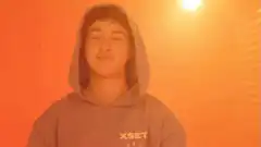 Guy in hoodie smiling with text