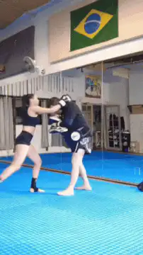 Woman practicing knee strike on trainer