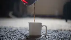 Pouring hot coffee into a white mug