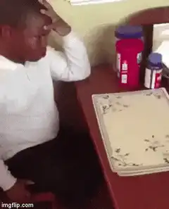 Man laughs then looks at table
