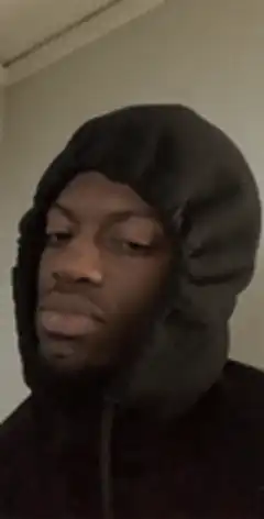 Man in black hood blinking slowly