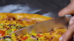 Knife cutting a pizza slice