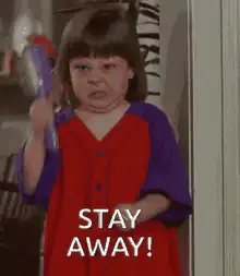 Angry toddler girl with toy gun saying stay away