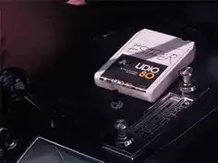 Hand inserting audio cassette into boombox