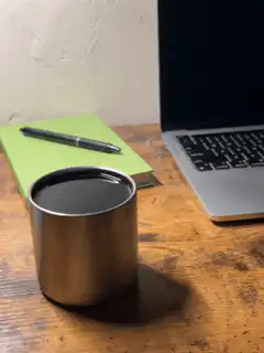 Coffee cup on desk next to laptop