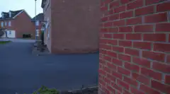 Man jumps out from behind brick wall