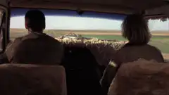 Two people in a car see flat plains instead of mountains