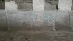 Man gestures at ancient wall mural