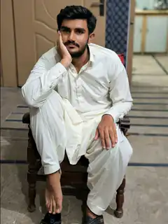 man in white shalwar kameez sitting on chair
