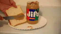 Spreading Jif peanut butter on bread