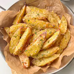 cheesy potato wedges in metal bowl