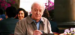 Michael Caine looking at a card