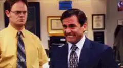 Michael Scott grimacing with Dwight behind him