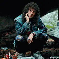 Eddie Van Halen sitting and looking around