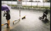 Woman blown over by strong wind in rain