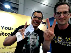 Two men at a convention holding tickets