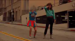 Two people dancing on a street