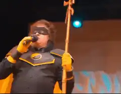 Man in superhero costume singing on stage