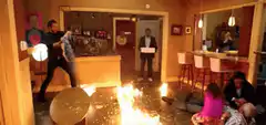 Man swings flaming bat in living room