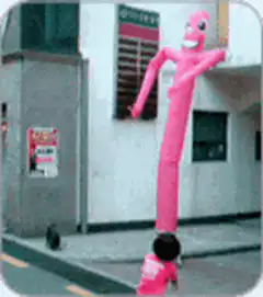 Pink inflatable tube man dancing on street