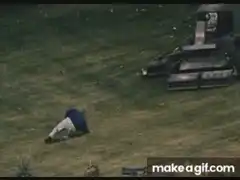 Man lying on grass as lawnmower approaches