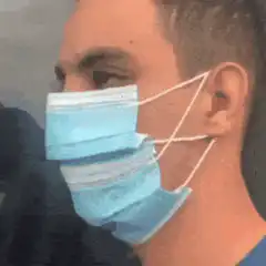 Man draws smile on surgical mask