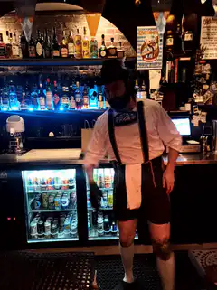 man in lederhosen dancing at bar