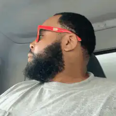 Man in red sunglasses points at camera