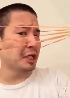 Man screaming with rubber bands on face