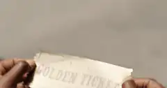 Hands revealing a Wonka Golden Ticket