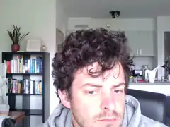 man with curly hair looking down