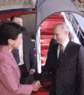 Vladimir Putin shaking hands with Xi Jinping