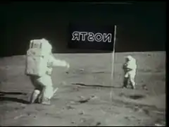 Astronauts on the moon with a flag