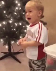 Toddler crying in front of Christmas tree