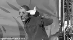 Person in mask pointing to head